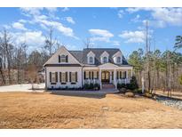 Charming two-story home with a covered porch, dormers, and beautiful landscaping at 175 Stonecrest Way, Pittsboro, NC 27312