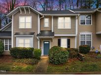 Inviting townhouse with beautiful landscaping, a blue front door, and neutral siding at 2268 Plum Frost Dr, Raleigh, NC 27603