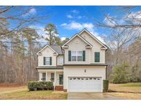 Charming two-story home with a two-car garage, landscaped yard, and a cozy front porch at 309 Amaryllis Way, Wake Forest, NC 27587