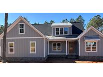 Charming gray home featuring vertical siding, a dark roof and stone accent base at 3909 Cedar Knolls Dr # 6, Youngsville, NC 27596