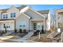 Charming townhome features gray siding, a blue front door, and well-manicured landscaping at 3928 Willow Gate Way, Raleigh, NC 27604