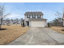 Charming two-story home with a light gray exterior, inviting front yard and a two car garage at 422 Pintail Ct, Durham, NC 27704