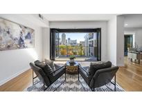 Bright living room featuring two leather chairs, an area rug, and balcony access with city views at 523 S West St # 502, Raleigh, NC 27601