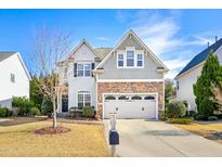 Charming two-story home featuring a stone facade, well-maintained landscaping, and a two-car garage at 1005 Forest Willow Ln, Morrisville, NC 27560