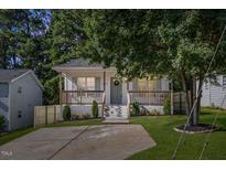 Charming home with a welcoming front porch, neat landscaping, and a freshly sealed driveway at 1011 Lowry Ave, Durham, NC 27701