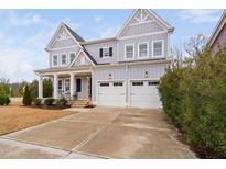 Charming two-story home features light blue siding, white trim, and a spacious two-car garage at 1105 Lowland St, Apex, NC 27523