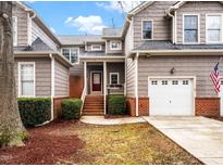 Charming townhome with a single-car garage, brick accents, and a well-manicured front yard at 1213 Red Beech Ct, Raleigh, NC 27614