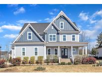 Charming two-story home with a covered front porch and professionally landscaped yard at 1421 Sweetclover Dr, Wake Forest, NC 27587