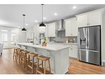 Modern kitchen with stainless steel appliances, white cabinets, and large island with counter seating at 1858 Fahey Dr, Apex, NC 27502
