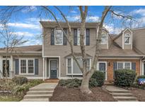 Charming townhouse featuring neutral siding, blue shutters, and a well-manicured front yard at 2 Forest Green Dr, Durham, NC 27705