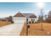 Charming single-Gathering home with attached two-car garage, paved driveway, and manicured lawn on a sunny day at 229 S Prince Henry Way Way, Cameron, NC 28326