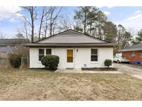 Charming single-story house featuring a white painted brick exterior, manicured landscaping, and a welcoming front entrance at 2305 Fitzgerald Ave, Durham, NC 27707