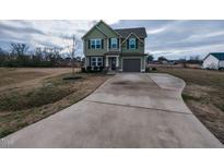Charming two-story home featuring an extended driveway, attached garage, and well-manicured lawn at 258 Denning Farms Ln, Benson, NC 27504