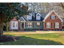 Charming two-story home featuring a mix of siding and brick, dormer windows, and a well-manicured lawn at 2713 Penfold Ln, Wake Forest, NC 27587