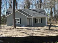 Charming one-story home features a symmetrical facade, a gabled roof, and a covered front porch with white pillars at 4694 Mcneill Hobbs Rd, Bunnlevel, NC 28323