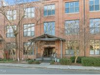 Elegant brick building entrance featuring covered entryway and well-maintained landscaping at 500 N Duke St # 55-103, Durham, NC 27701