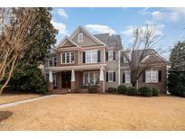 Beautiful two-story home featuring a brick and siding exterior, a manicured lawn, and a welcoming front porch at 5000 Sears Farm Rd, Cary, NC 27519
