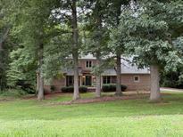 Charming brick home nestled among mature trees, offering a serene and private setting at 5512 Spring Bluffs Ln, Raleigh, NC 27606