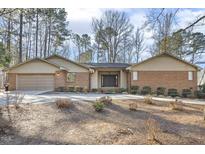Charming single-story brick home with well-maintained landscaping and a spacious driveway at 6065 Merion Cir, Sanford, NC 27332