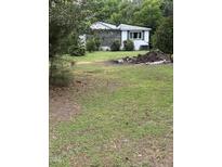 A quaint single story home with a screened in porch and an ample lawn and mature trees at 652 Old Sanford Rd, Moncure, NC 27559