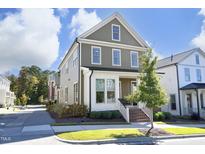 Charming two-story home featuring a covered porch, neutral siding, white trim, and beautifully landscaped front yard at 1005 Whistler St, Durham, NC 27713