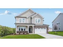Charming two-story home with brick and siding, featuring a well-maintained lawn and attached two-car garage at 101 Hiddenite Pl, Holly Springs, NC 27540