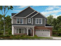 Charming two-story home featuring a brick facade, gray siding, and a welcoming front porch at 101 Hiddenite Pl, Holly Springs, NC 27540