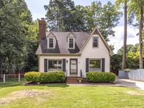 Charming home with manicured lawn, dark shutters, and a brick chimney at 104 Pinecroft Dr, Raleigh, NC 27609