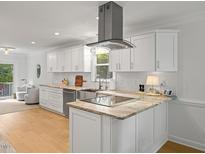 Bright kitchen features white cabinetry, stone countertops and stainless steel appliances at 104 Pinecroft Dr, Raleigh, NC 27609