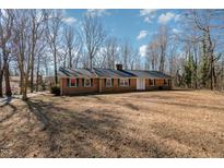 Charming one-story brick home featuring a well-maintained lawn and a classic architectural style at 1103 Driftwood Dr, Siler City, NC 27344