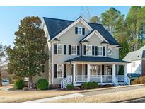 Charming two-story home with a covered front porch, black shutters, and a well-manicured lawn at 114 Lansbrooke Ln, Apex, NC 27502