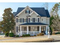 Charming two-story home with a covered front porch, black shutters, and manicured landscaping at 114 Lansbrooke Ln, Apex, NC 27502