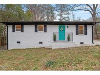 Charming home with a vibrant teal front door and fresh white brick exterior at 2607 Nation Ave, Durham, NC 27707