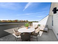 Outdoor patio featuring a lounge set, table, and seating with distant treetop views and sunny skies at 2900 Kempthorne Rd # 57, Cary, NC 27519