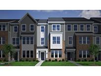 Charming townhome showcasing a blend of gray siding, brick accents, and manicured green lawn at 319 Chesapeake Commons St # 103, Garner, NC 27529