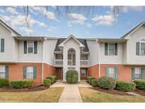 A charming townhouse with white siding, red brick accents, and manicured landscaping at 3322 Wellington Ridge Loop, Cary, NC 27518