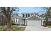 Charming gray two-story home featuring an attached two-car garage and a well-manicured front yard at 5 Bonham Ct, Durham, NC 27703