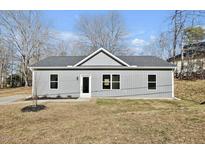 Newly constructed home with gray siding, a manicured lawn, and a concrete driveway at 819 Springdale Dr, Durham, NC 27707