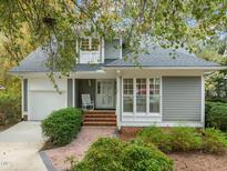 Charming home features gray siding, white trim, and a brick walkway leading to the front door at 10 Marchmont Ct, Durham, NC 27705