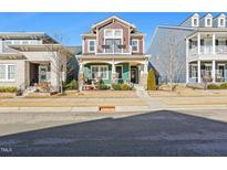 Charming two-story home with brown and teal siding, balcony, and well-maintained landscaping at 1132 Gloriosa St, Apex, NC 27523