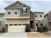 Charming two-story home featuring mixed siding, stone accents, attached garage, and inviting entrance at 1546 Tinos Overlook Way, Apex, NC 27502