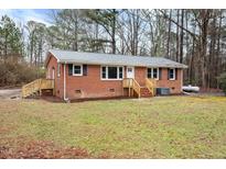 Quaint one-story brick home featuring a wooden entrance staircase and ample yard space at 2116 Nc Highway 751, Apex, NC 27523