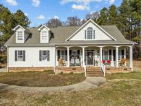 Charming home featuring a welcoming front porch with swing and rocking chairs at 226 Fletcher Ridge Rd, Timberlake, NC 27583