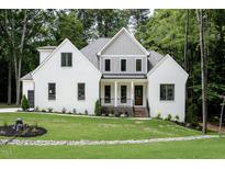 Charming two-story home with a landscaped yard and painted brick at 2410 Carpenter Pond Rd, Raleigh, NC 27613
