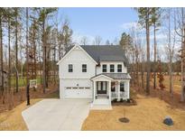 Charming two-story home with white siding, stone accents, and a welcoming front porch at 280 Scotland Dr, Youngsville, NC 27596