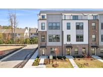 A modern multi-story townhome showcasing brick and siding accents and upper level terraces at 2906 Kempthorne Rd # 54, Cary, NC 27519