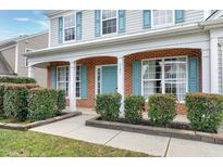Charming home exterior featuring a brick facade, light blue door and shutters, and manicured landscaping at 303 Shakespeare St, Morrisville, NC 27560