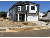 Two-story gray home featuring a two-car garage, stone accents, and a well-manicured lawn at 4301 Darius Lane # 28, Fuquay Varina, NC 27526