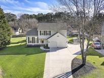 Charming two-story home with well-manicured lawn and a long driveway leading to a two-car garage at 4709 Wyndchase Ct, Fuquay Varina, NC 27526