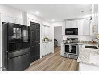 Modern kitchen features stainless steel appliances, white cabinets, and granite countertops at 6309 Cape Charles Dr, Raleigh, NC 27617